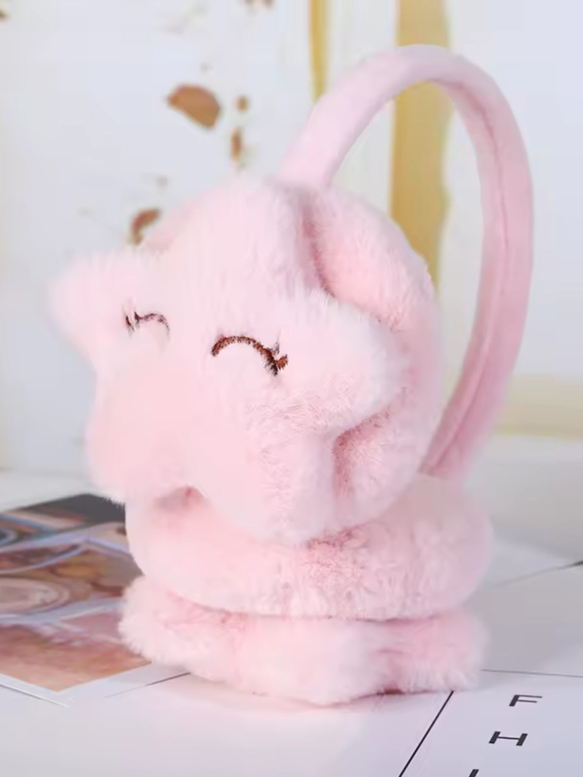 Cache oreille fille avec un design d'étoile rose clair